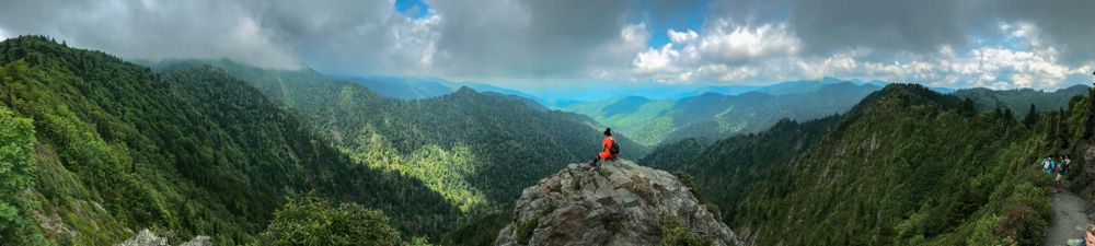 A hiker sitting on the peak of Smoky Mountain National Park