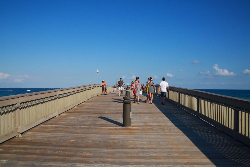 People walking along Deerfield Beach International Fishing Pier