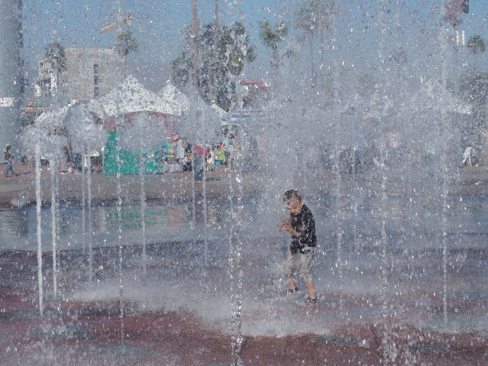 A child in the middle of Parque De La Bandera's water fountain