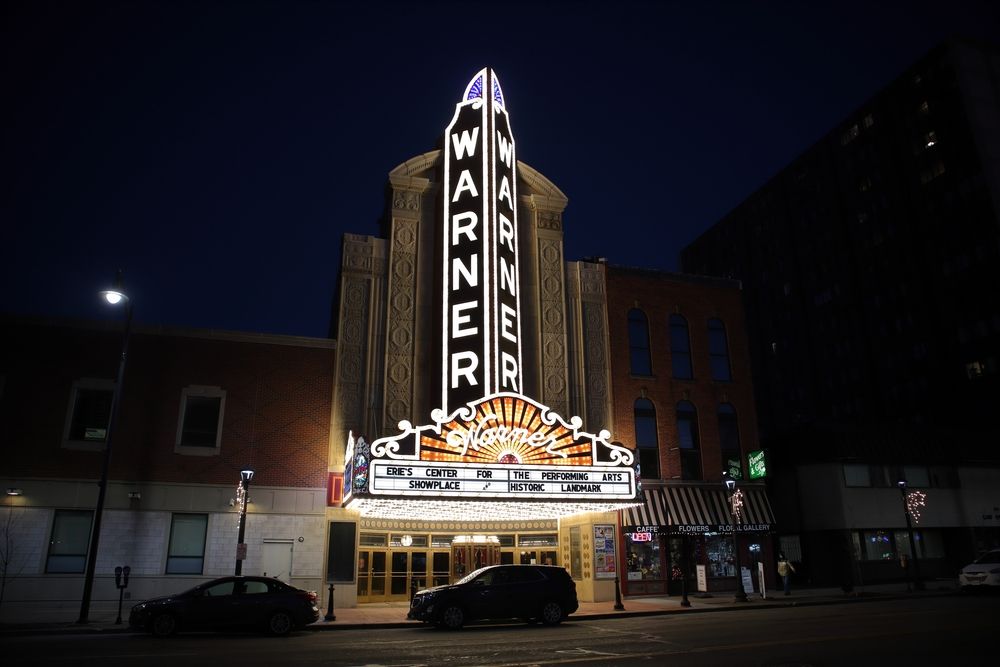 Bright night lights illuminating Warner Theatre's exterior