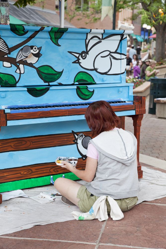 An artist painting a piano for Pianos About Town