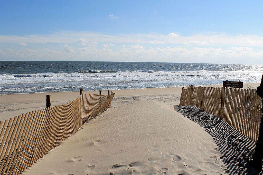 Wooden fence on the sand - leading the way to the shore.