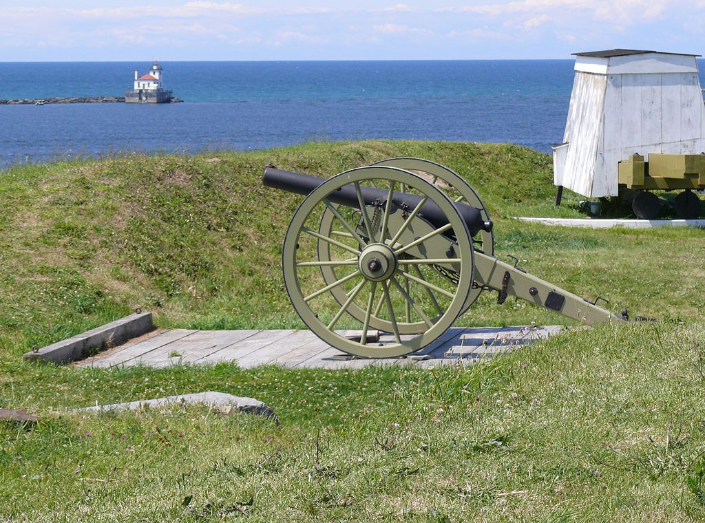 An old artifact sitting on the green grass of Fort Ontario.