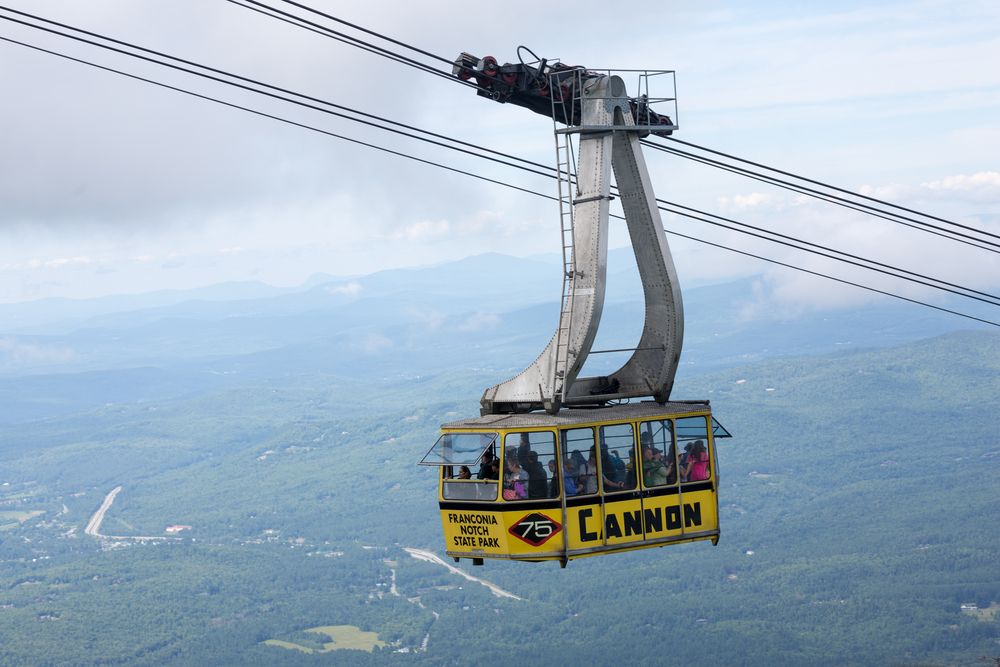 Tourist enjoying the scenic view of Franconia while riding a cable car.
