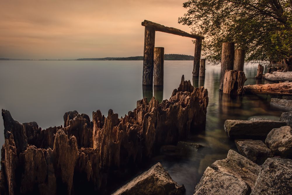 Woods and the still waters of sunrise beach park at dawn.