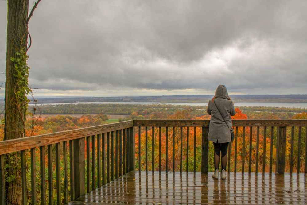 A woman overlooking the colorful autumn trees in Pere Marquette state park.