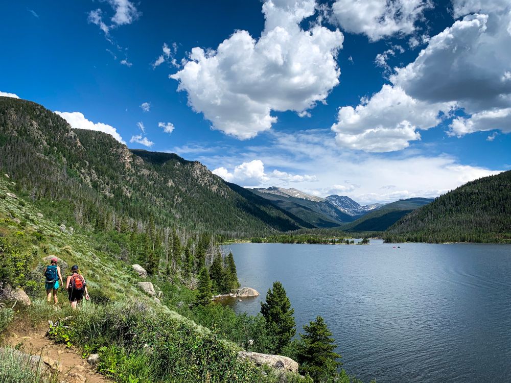 Hikers on a trail beside Lake Granby