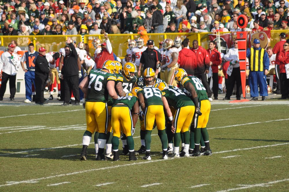 The green bay packers huddle during a football match in Lambeau Field