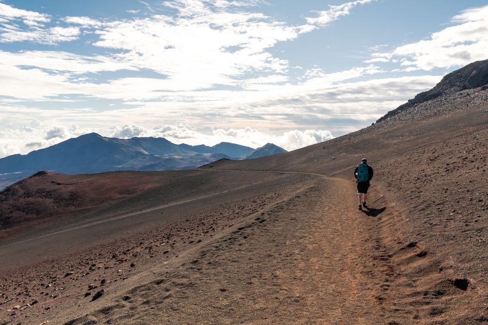 A hiker walking along sliding sands trail at Haleakala Crater