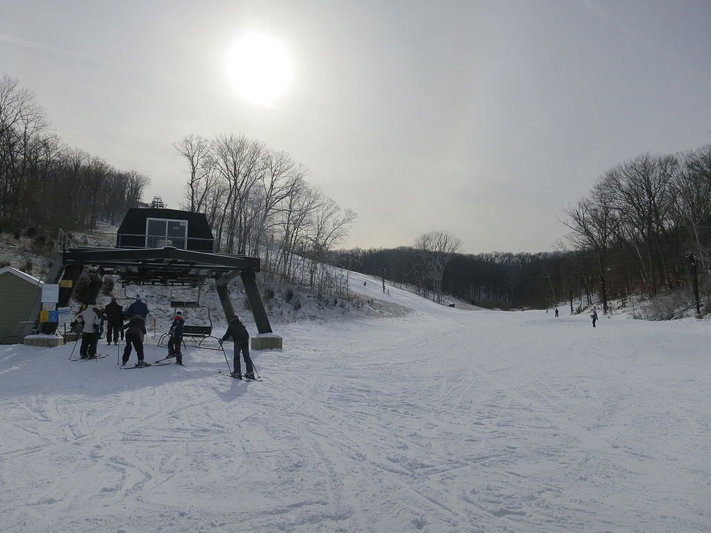A few people skiing the snowy mountains at hidden valley.