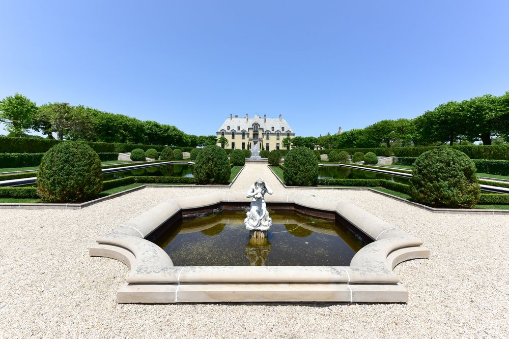Exterior view of the oheka castle and a fountain.