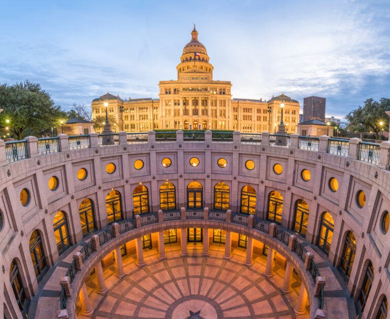 A twilight view of the Texas State Capitol in Austin, Texas, USA, showcasing the illuminated building and its surrounding architecture.