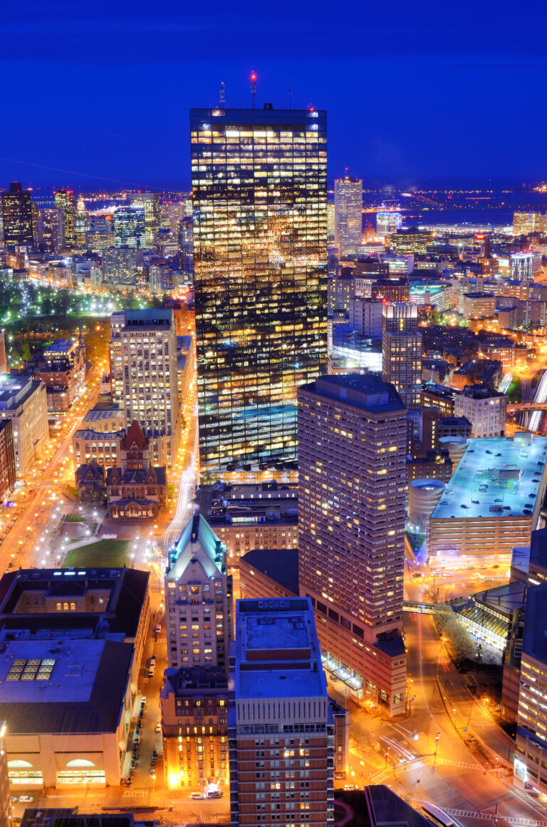 A vibrant night view of a bustling cityscape with illuminated skyscrapers and streets.