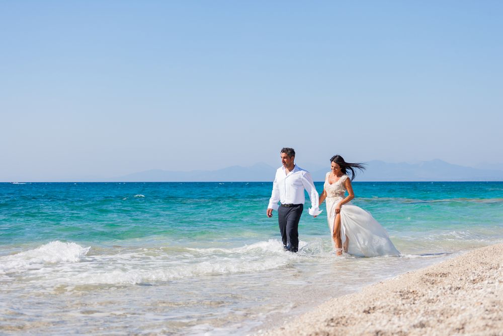 Bride and groom walking on the beach of Kefalonia