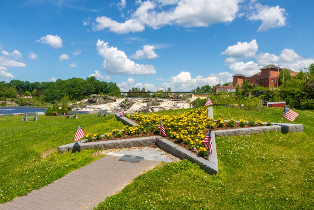 A star shaped rock with flowers and flags at Veterans Memorial Park.