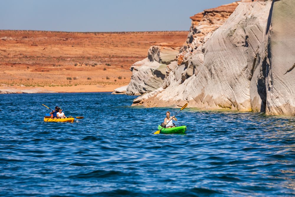 People kayaking beside Lone Rock