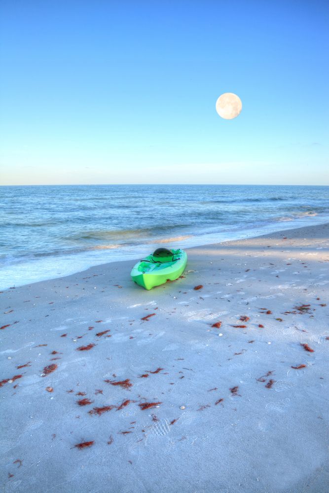 A green kayak on the shore of marco island