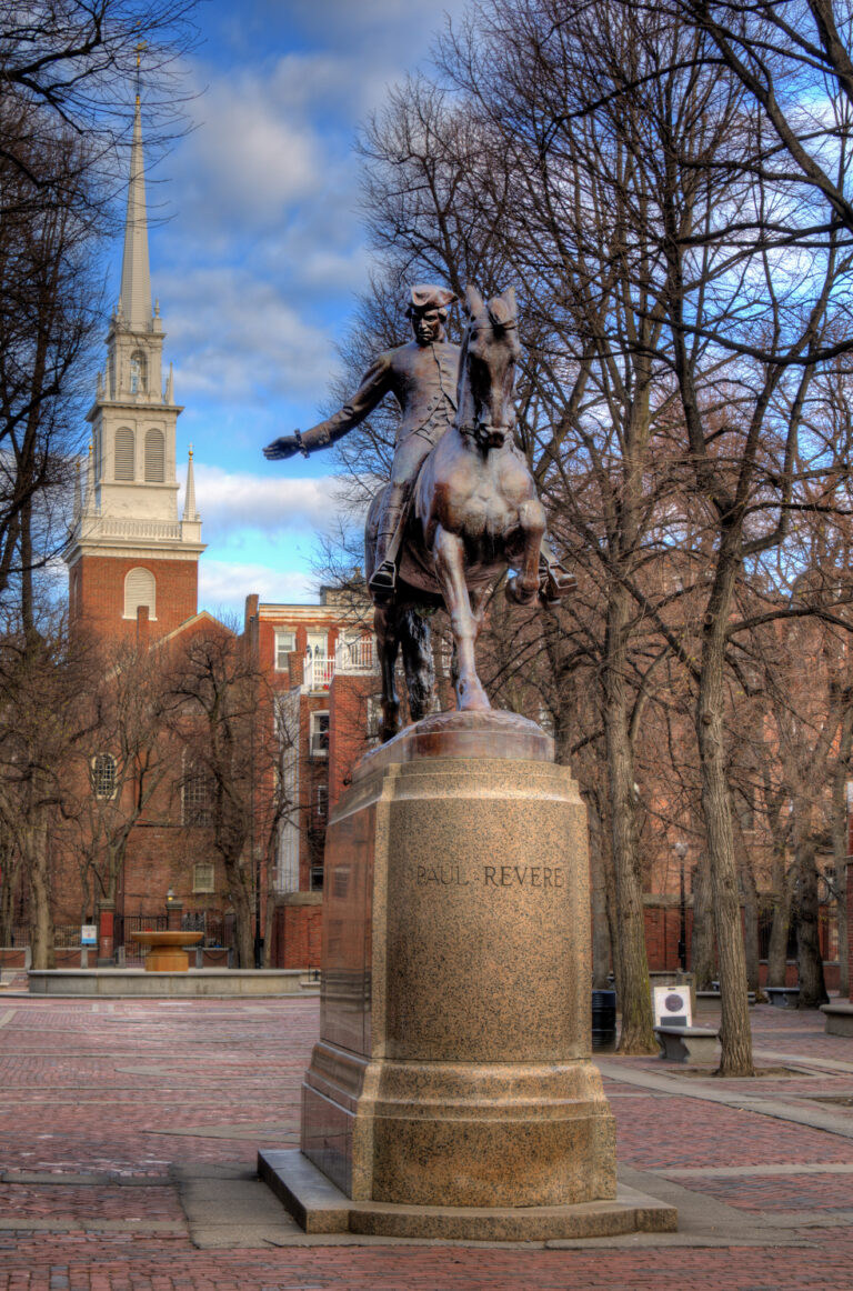 A statue of Paul Revere on horseback is prominently displayed in the Paul Revere Mall, with the historic Old North Church visible in the background.