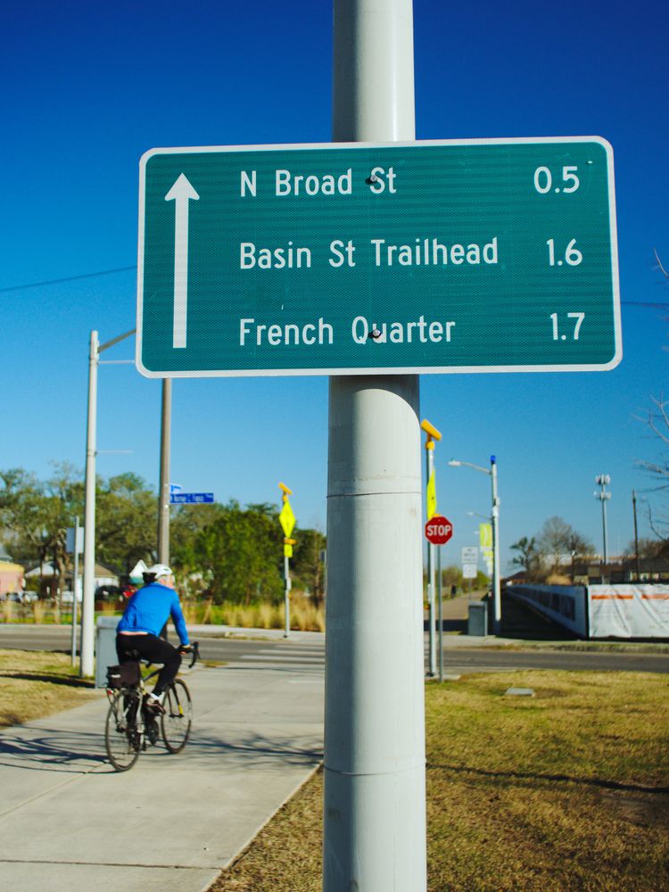 A person riding a bicycle along Lafitte Greenway
