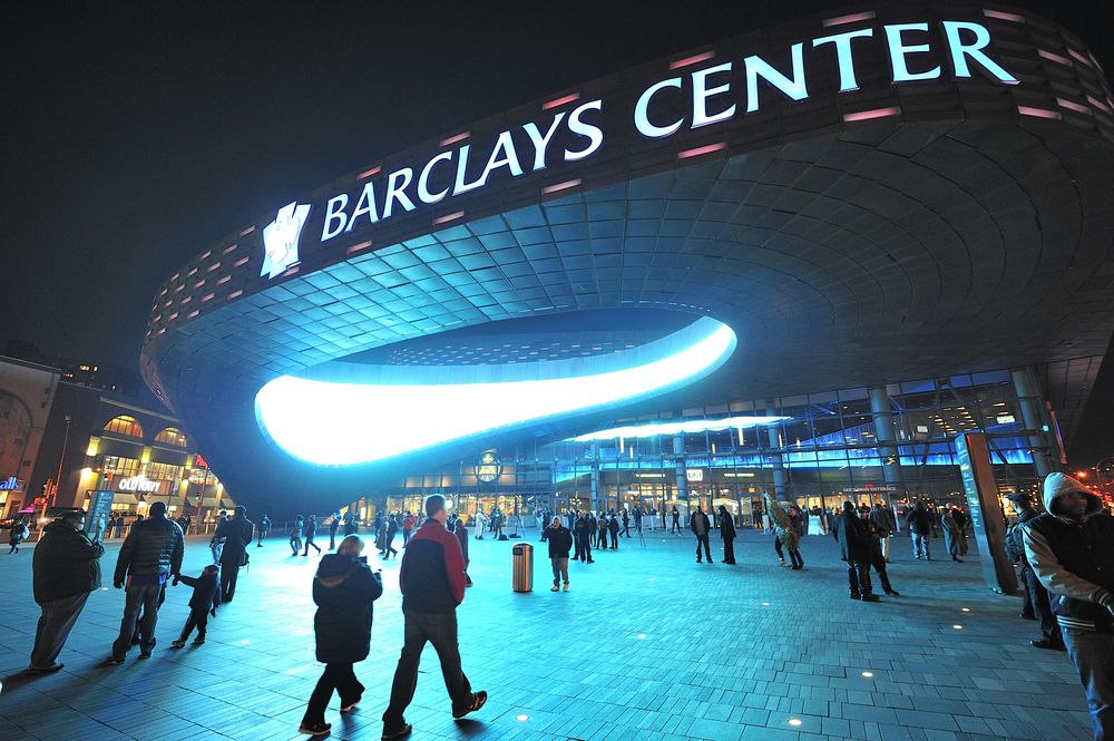 Barclays center name sign near the entrance with people around it.