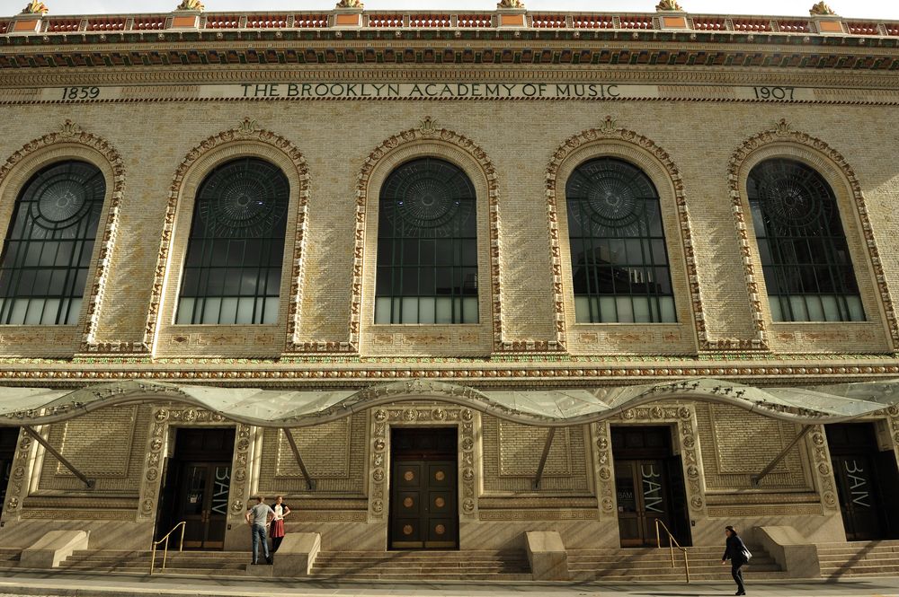Front exterior view of the brooklyn academy of music building - with people standing in front.