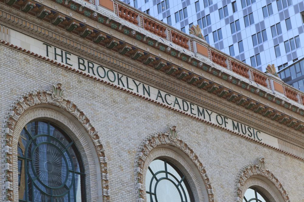 The brooklyn academy of music name on top of the building exterior.