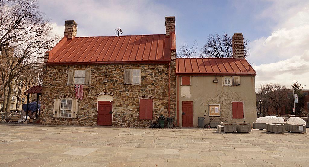 Stone walls and red roof of the old stone house exterior.