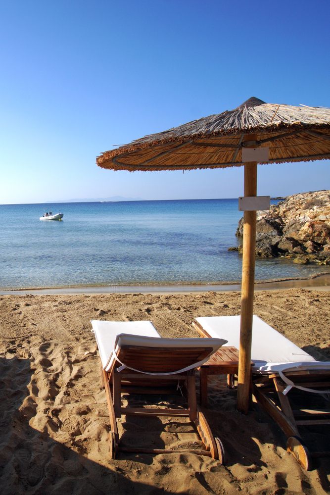 Straw umbrella and loungers on Faragas Beach's sand