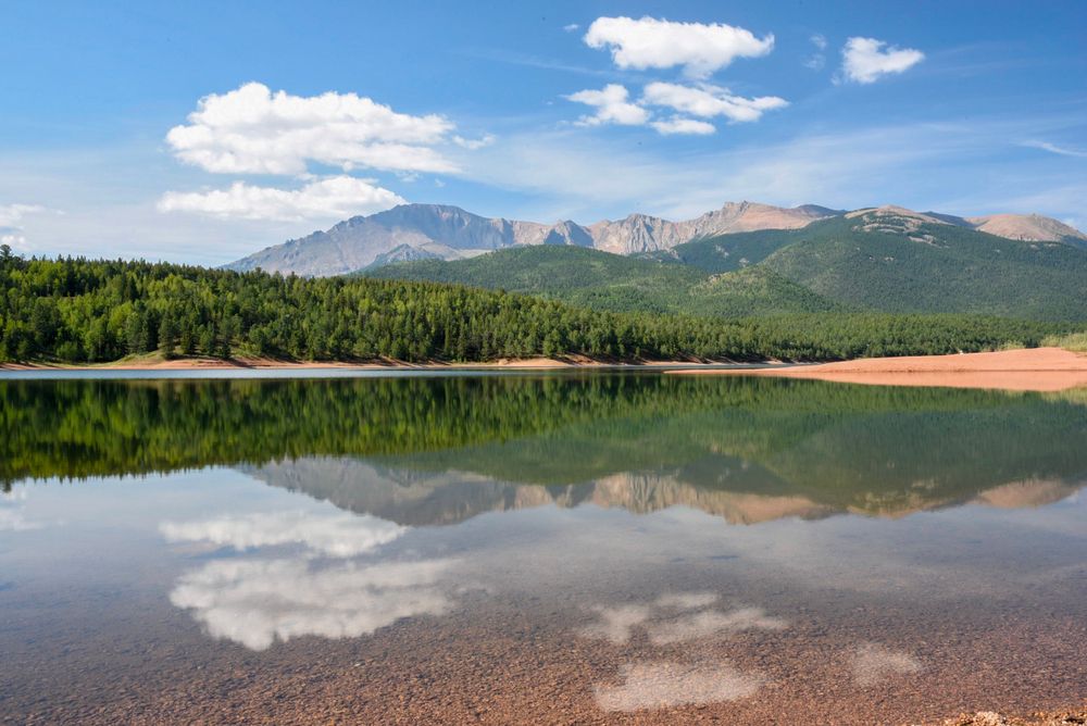 Trees and mountains reflecting on Crystal Creek Reservoir