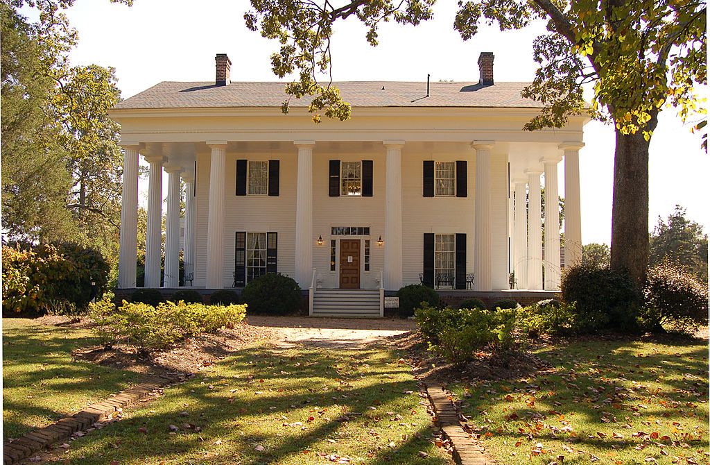 Front view of the barrington hall exterior with white walls and green landscape.