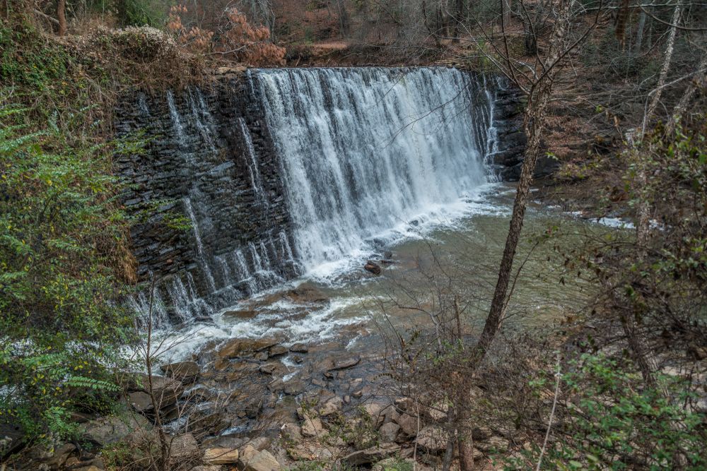 Side aerial view showing the rushing waters from roswell mill waterfall.