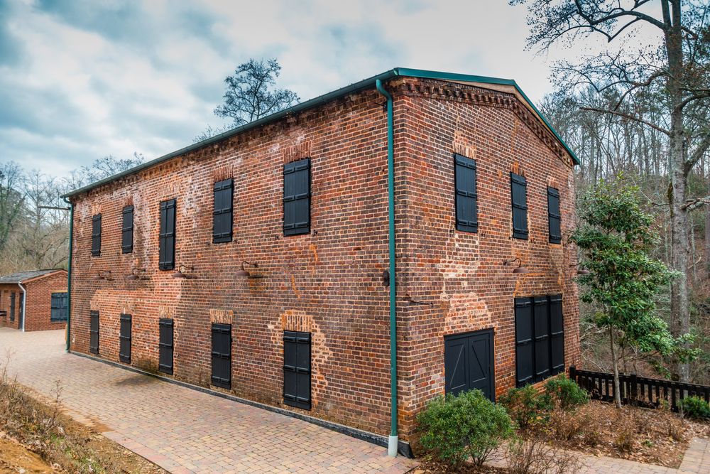 A brick house at the old mill park with black colored doors and windows.