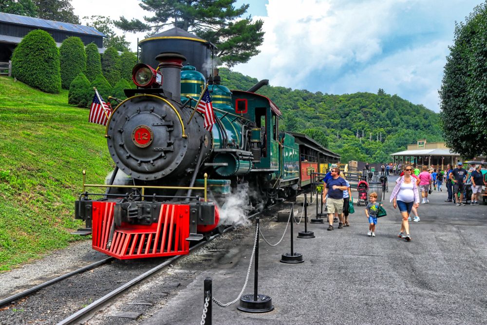 People walking beside Tweetsie Railroad's steam locomotive