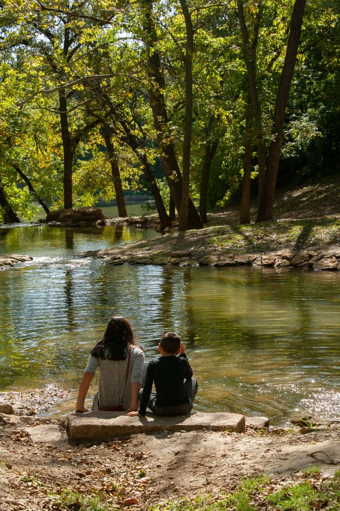 Kids sitting near the waters of Krug Park