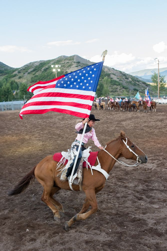 A woman riding a horse at the rodeo.