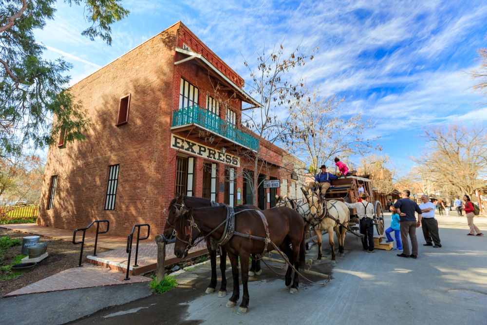 Exterior view of a building in state park - with horses and people.