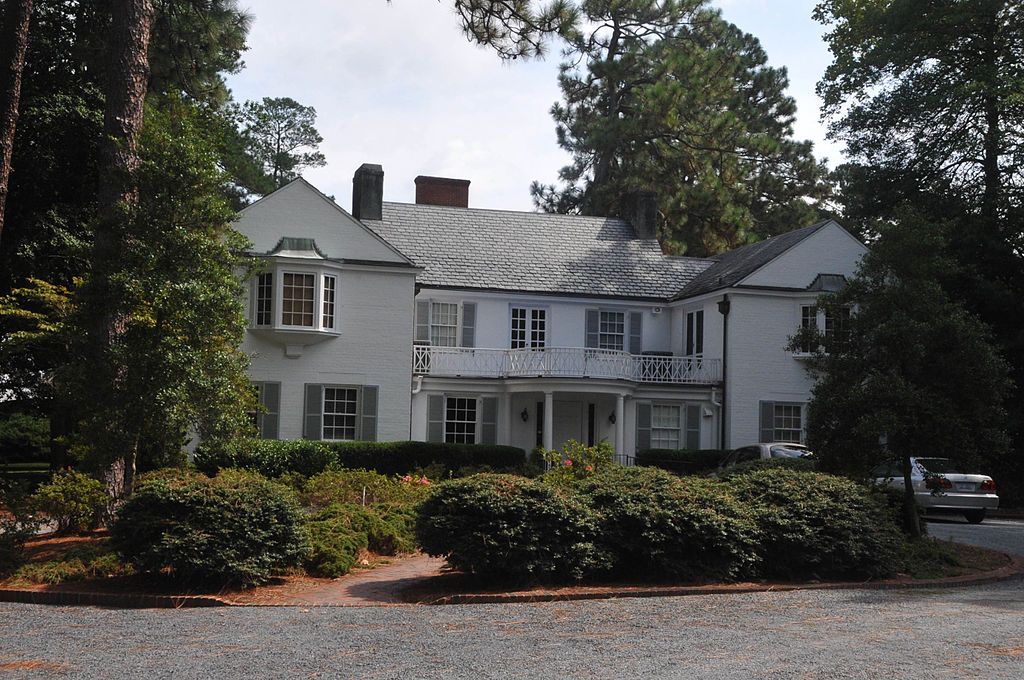 Bushes in front of a white colored house.