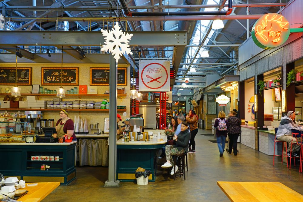 A bakeshop inside the market with people eating or walking.