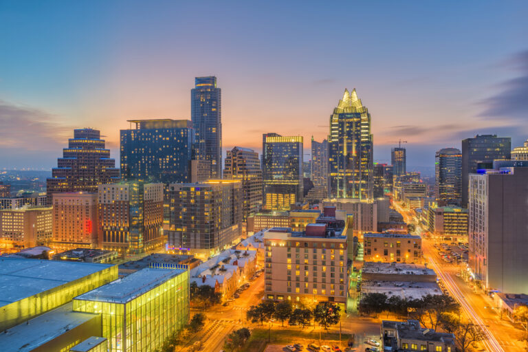 A dusk view of Austin, Texas, USA, showcasing the cityscape with illuminated buildings under a fading sky.