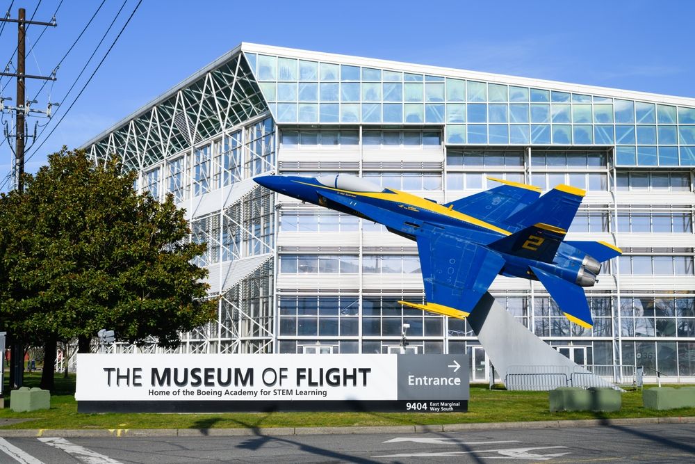 A blue plane statue and name sign of The Museum of Flight.