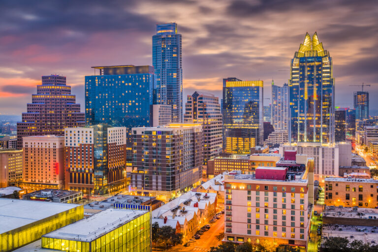 A dusk view of Austin, Texas, USA, showcasing the downtown cityscape illuminated by the warm glow of the setting sun.