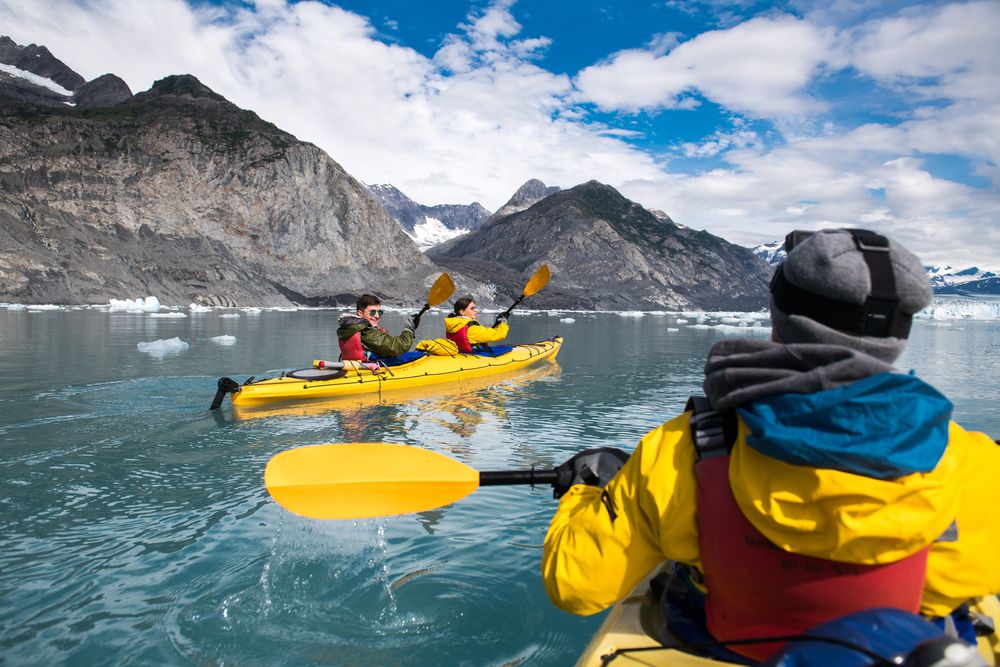 Three people kayaking along Columbia Glacier