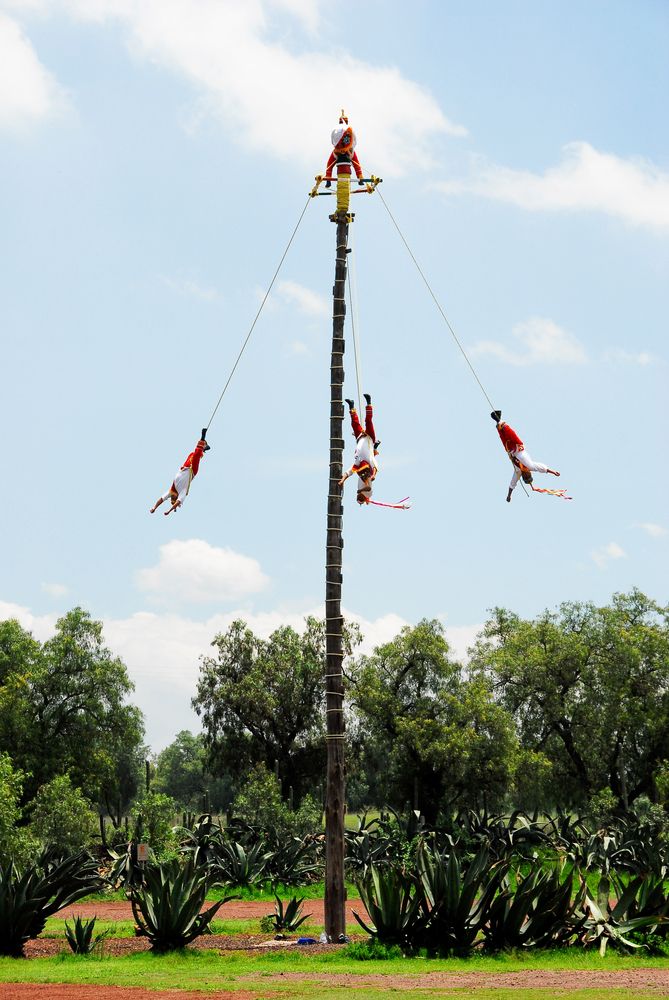 Men dangling from a pole for the Danza de los Voladores ceremony