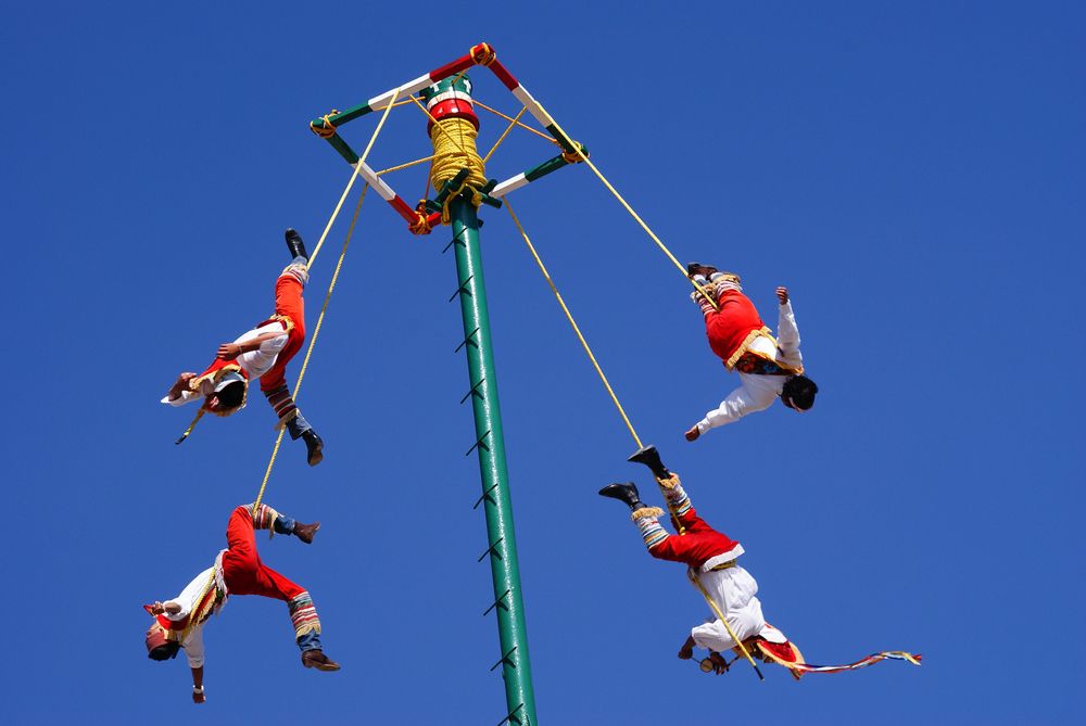 Papantla flyers dangling from a pole for Danza de los Voladores ceremony