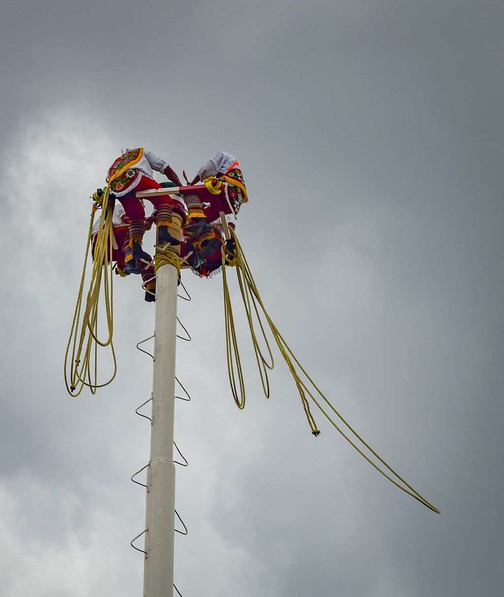 Men on top of poles for the Dance of the Flyers ceremony