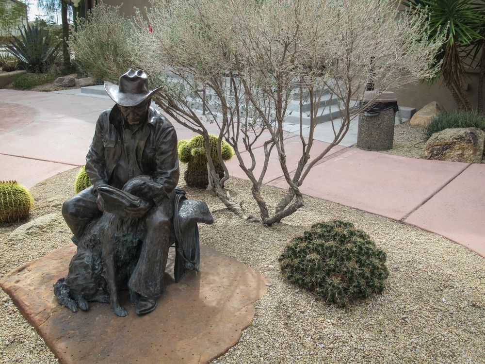 Statue of a cowboy and his dog on the grounds of Desert Caballeros Western Museum