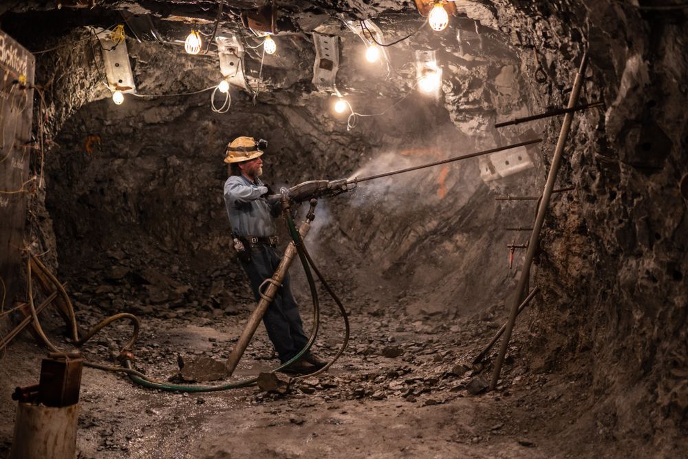 A tour guide demonstrating an equipment during the Sierra Silver Mine Tours