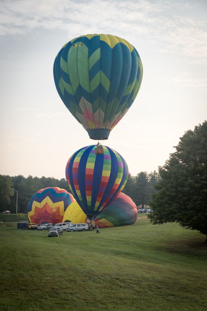 Rainbow colored hot air balloons on the ground.