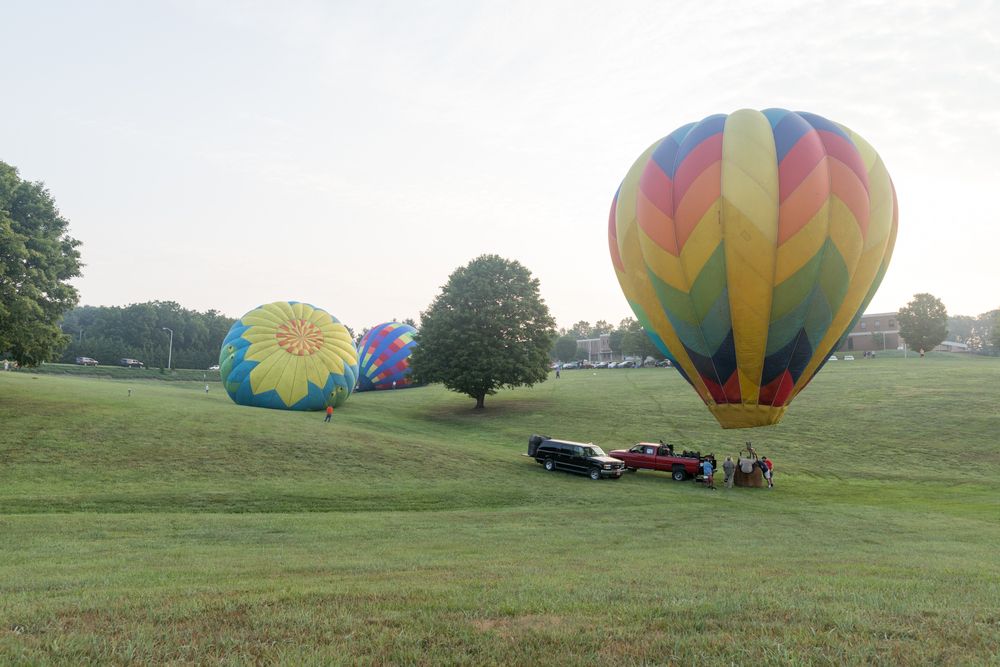People getting on the colorful hot air balloon.
