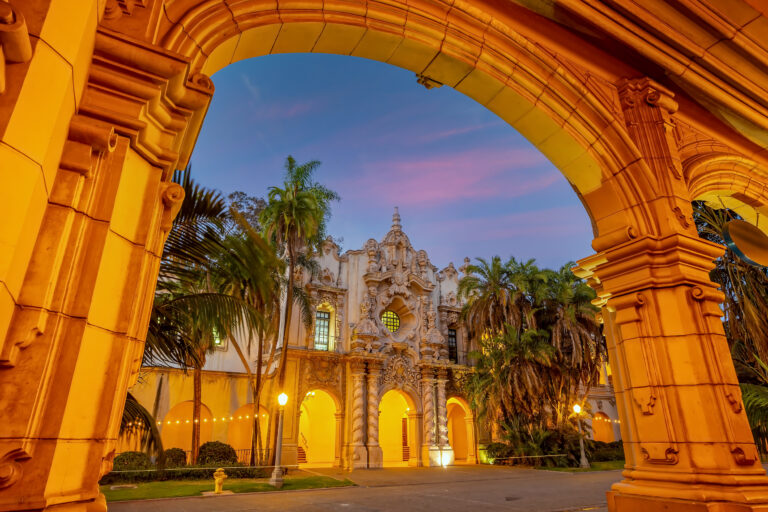 The warm glow of sunset bathes the historic architecture of San Diego’s Balboa Park in a serene light, highlighting the beauty of this beloved California landmark.